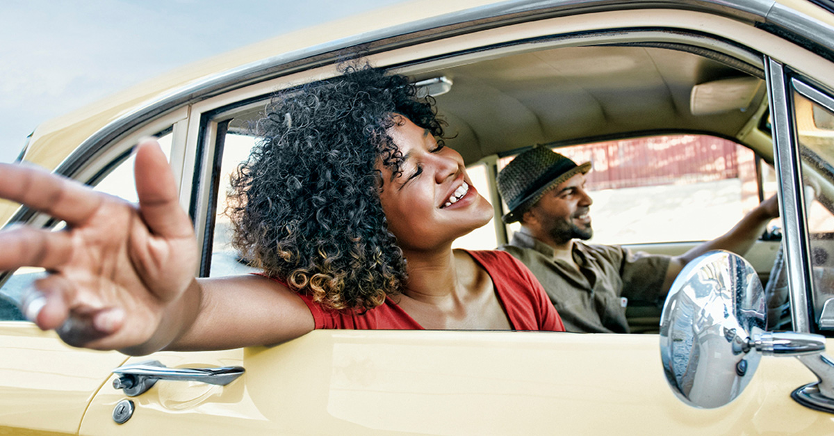 Woman sticking arm out window of car